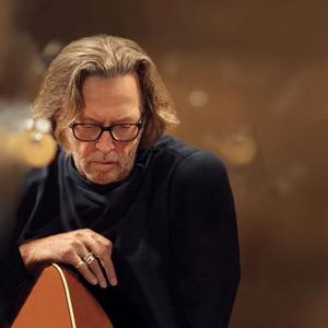 Eric Clapton naslonjen na gitaru Outlet Visit