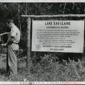 1955 Press Photo Conservation Worker Standing Next to No Fishing Limit Sign Clearance Great Deals