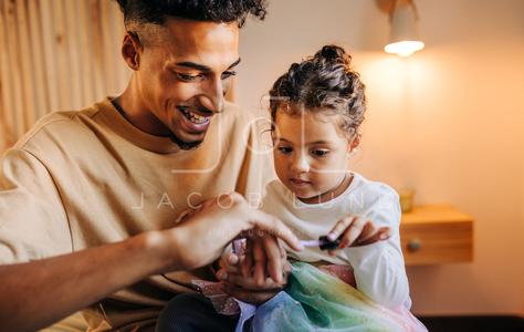 Adorable little girl applying nail polish on her dad's nails Best Place To Buy